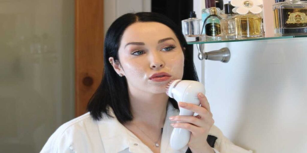 A woman holding a hair dryer in her hand.