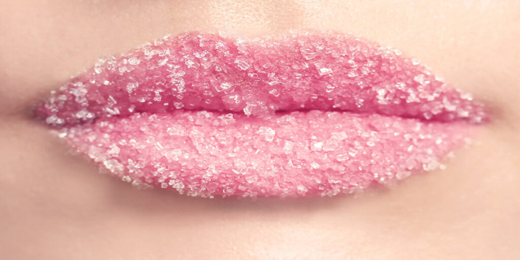 A close up of the lips with pink lipstick