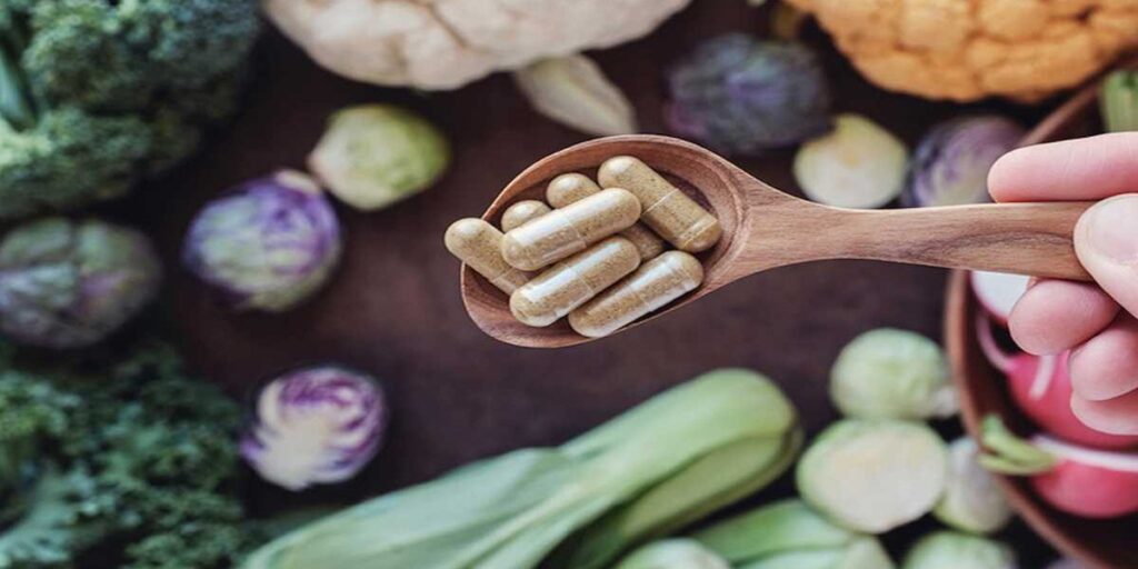 A wooden spoon with some pills on it