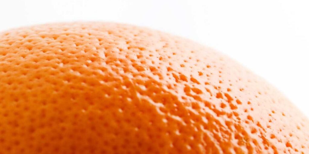 A close up of an orange on a white background