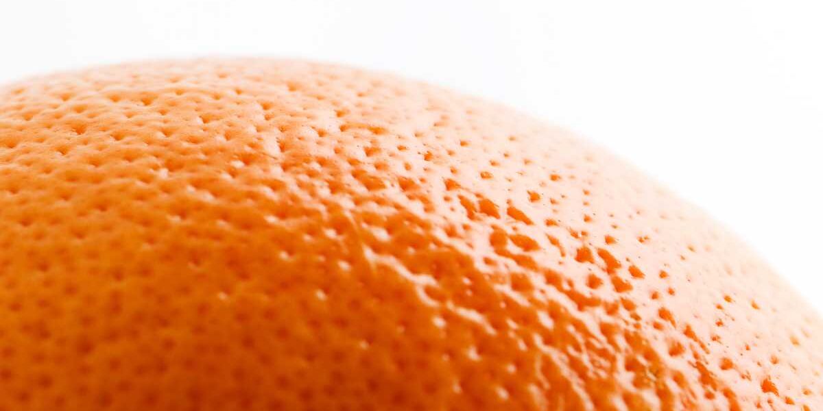 A close up of an orange on a white background