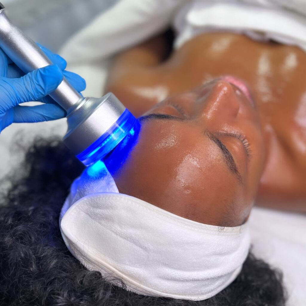A person getting their face cleaned with an electric device.