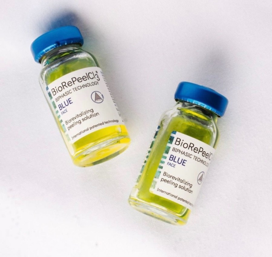 Two small bottles of yellow liquid sitting on top of a table.