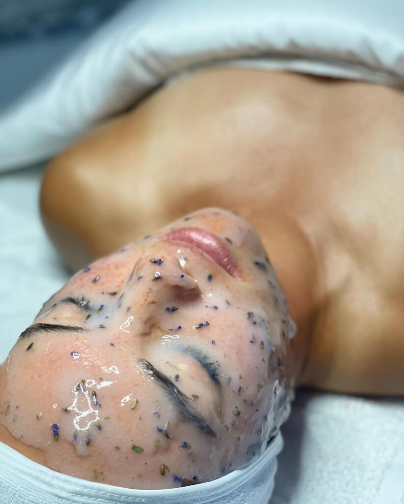 A woman laying on top of her face with a sponge.