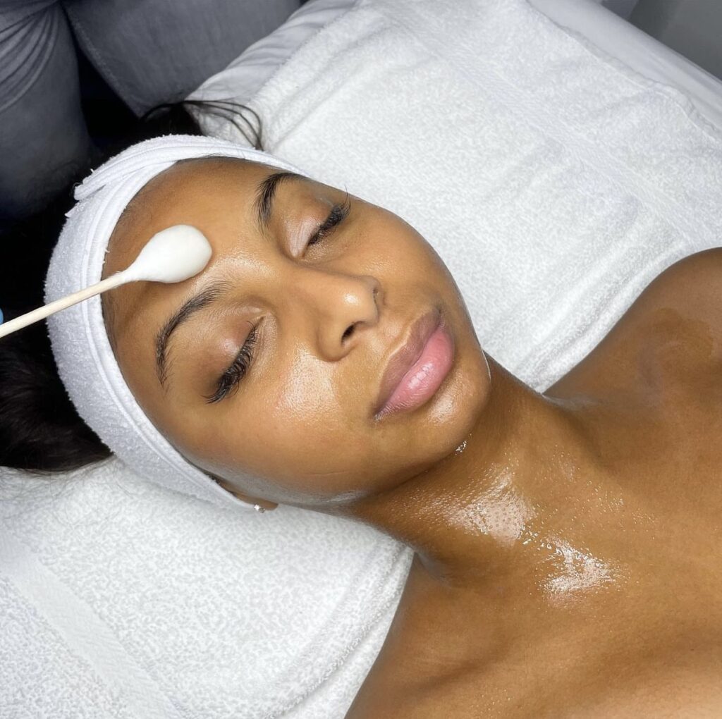 A woman laying down with a white towel on her head.
