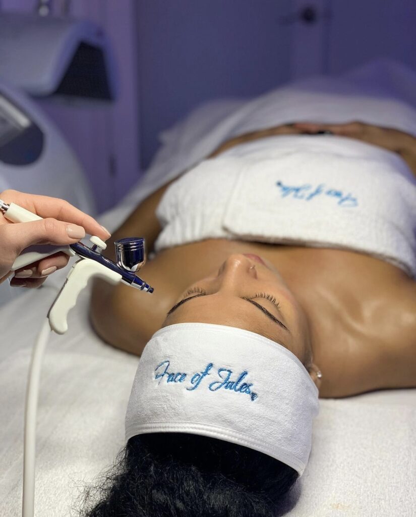 A woman getting her face painted with white paint.